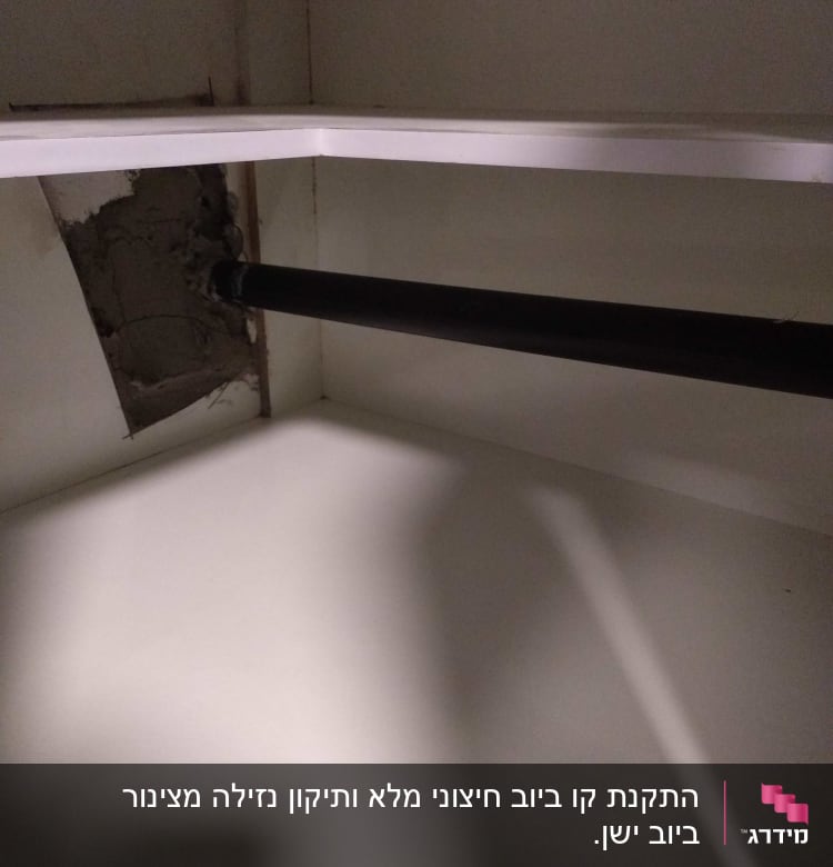 צינור שחור מותקן בקיר עם חור בטיח